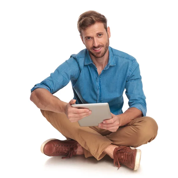 Entspannter Junger Mann Sitzt Beim Lesen Auf Tablet Auf Weißem — Stockfoto