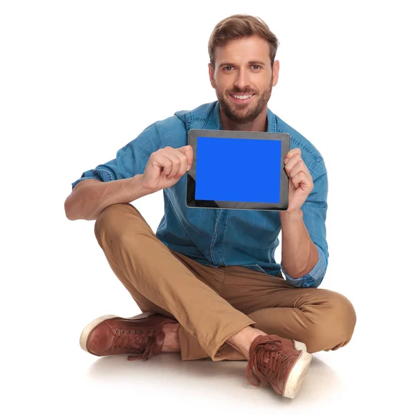 Lächelnder Lässiger Mann Sitzt Und Zeigt Den Leeren Bildschirm Auf — Stockfoto