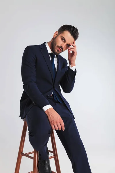 Portrait Pensive Businessman Navy Suit Sitting Wooden Stool Light Grey — Stock Photo, Image