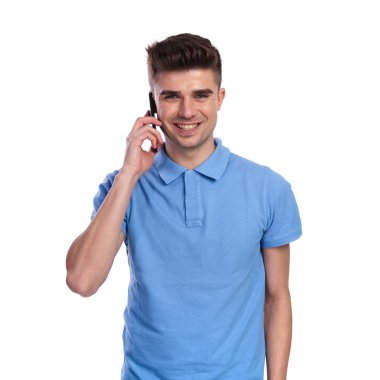 Genç mutlu casual adam beyaz arka plan üzerinde telefonda konuşuyor