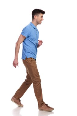 Beyaz arka plan üzerinde yürüyen bir genç casual adam yan görünüm