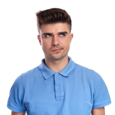 Genç casual adam düşünüyor ve beyaz arka tarafa bakar