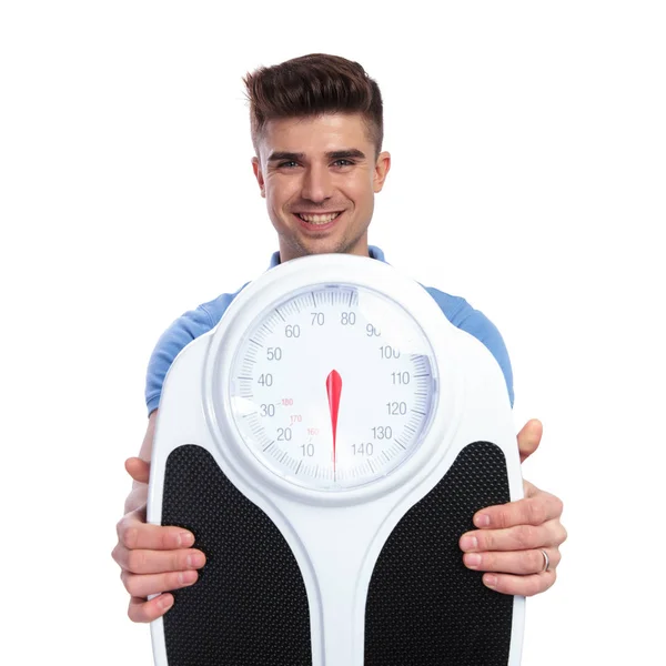 Sorrindo Homem Casual Segurando Mostrando Uma Escala Fundo Branco — Fotografia de Stock