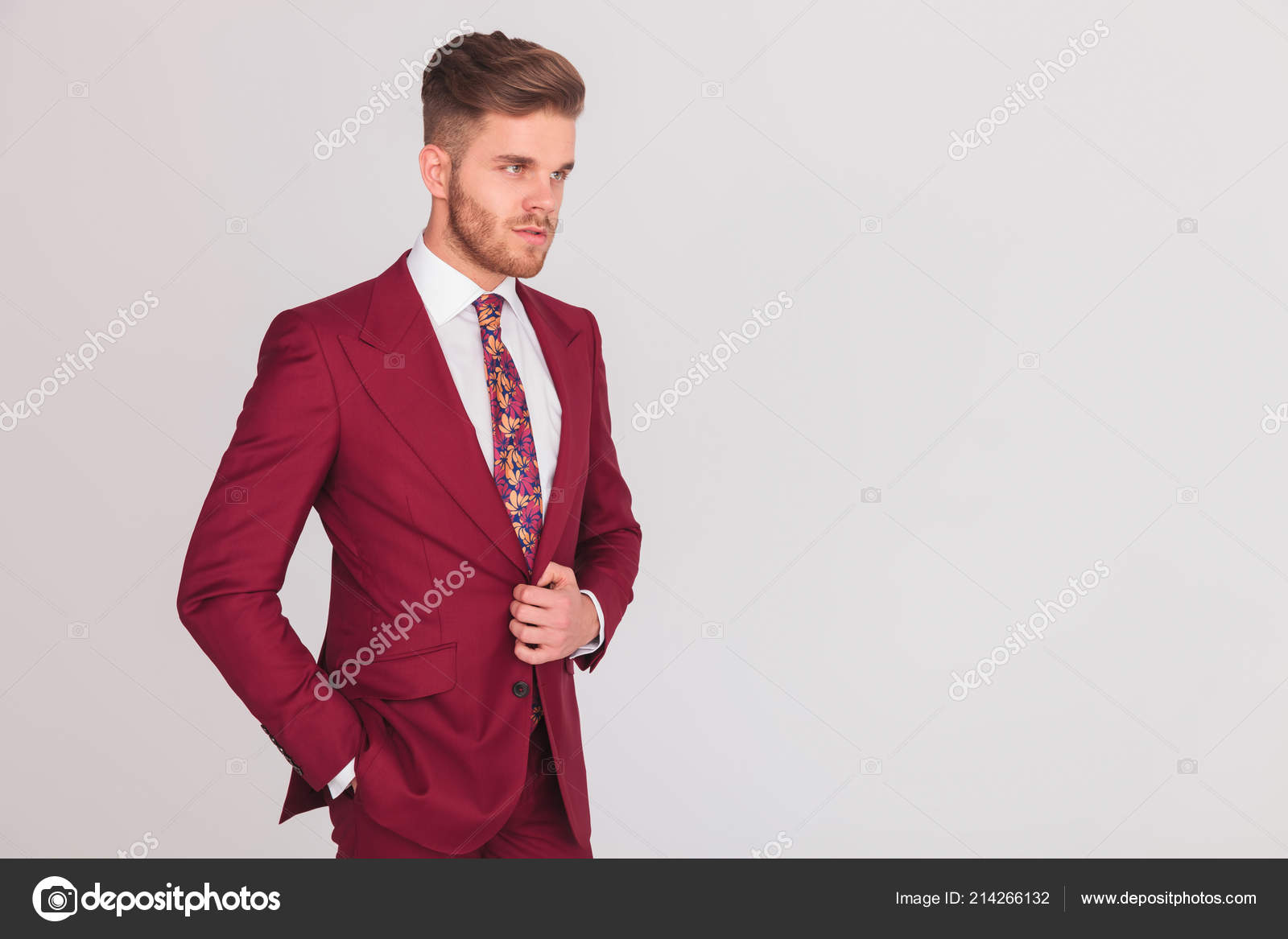 ポケットやその他の彼のスーツのボタンを押したまま片方の手で灰色の背景の上に立ってリラックスしたモダンなビジネス男の側のビュー肖像 ストック写真 C Feedough