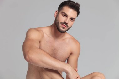 seksi çıplak oturan adam gri arka plan üzerinde poz portresi