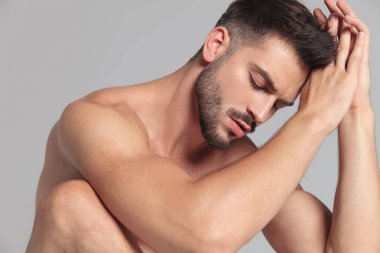 yakın üzgün bir adam, avuç içi ile gri arka plan üzerinde prayingr birlikte