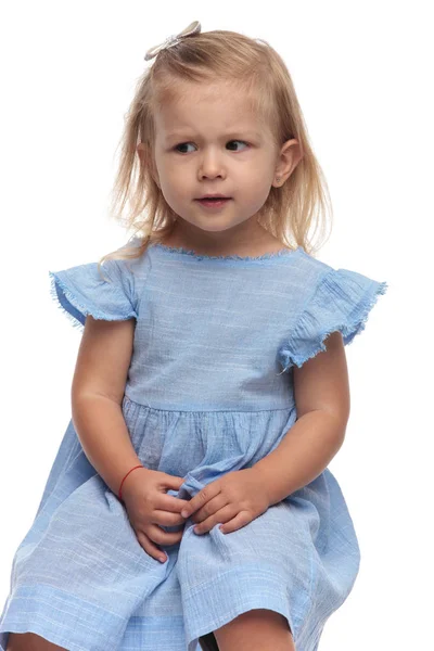 Zaměnit Malá Roztomilá Dívka Sedí Vypadá Stranu Bílém Pozadí — Stock fotografie