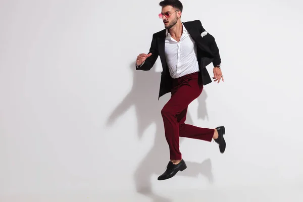 Hombre Guapo Con Traje Negro Gafas Sol Rojas Saltando Lado —  Fotos de Stock