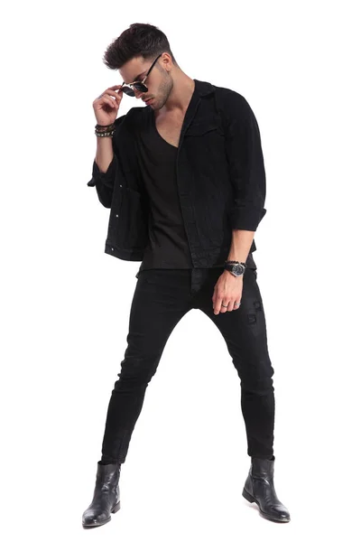 Przystojny Mężczyzna Dzień Czarne Ubrania Rozwiązuje Okulary Patrzy Bok Stojąc — Zdjęcie stockowe