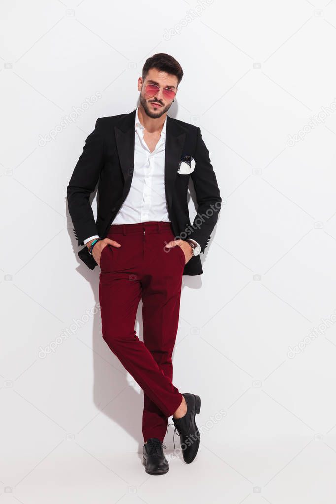 relaxed handsome man wearing black suit and red sunglasses