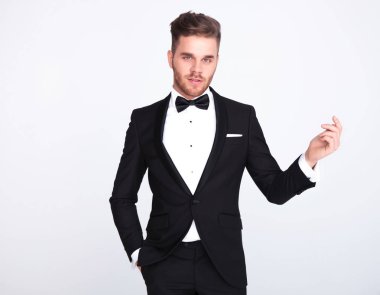 Smokin ışık gri arka plan üzerinde duran parmak dayama rahat bey portresi