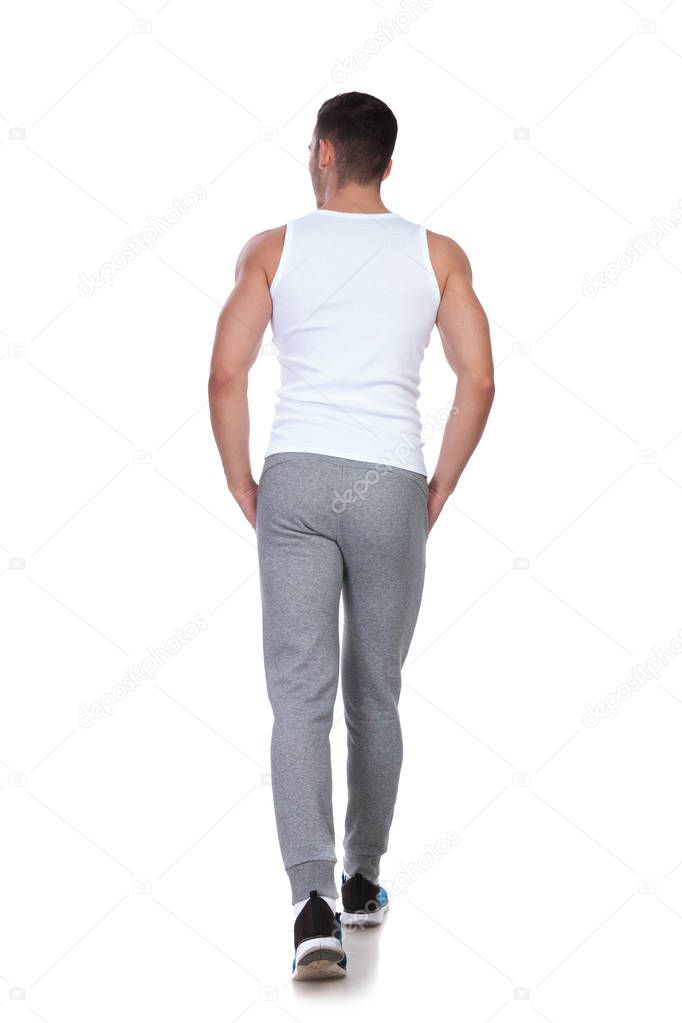 rear view of relaxed man walking on white background and looking to side