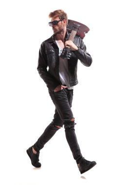 Beyaz arka plan üzerinde adım ve omzuna, tam uzunlukta resim onun elektro gitar tutarken arkasında seyir rahat gitarist yan görünüm
