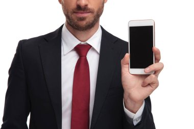 bir takım elbise ve beyaz arka plan üzerinde duran cep telefonu sunulması kırmızı kravat giyen işadamı vücut yakın çekim