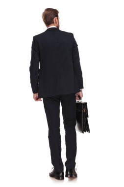 Dikiz işadamı beyaz arka plan üzerinde adım ve tarafına bakarak çanta