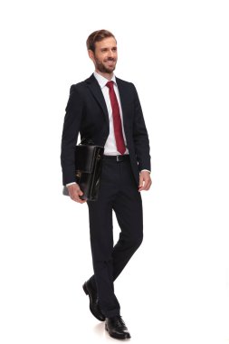 Evrak Çantası'nı tutan genç işadamı beyaz arka plan üzerinde adımlar ve yan, tam uzunlukta resme benziyor