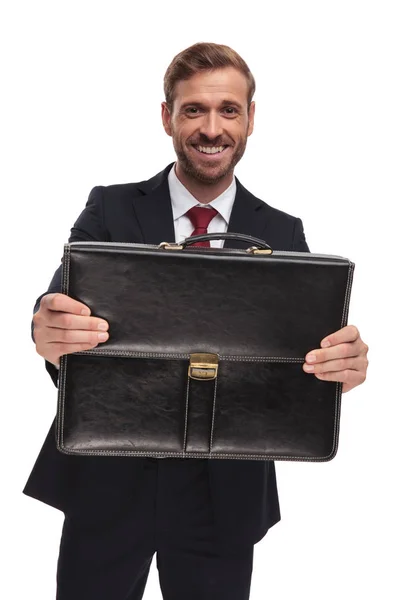 Portret Szczęśliwy Elegancki Biznesmen Oferując Jego Teczki Stojąc Białym Tle — Zdjęcie stockowe