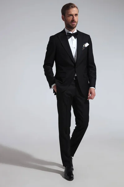 Elegant Man Tuxedo Standing Hand Pocket Gray Background Looks Away — Stock Photo, Image