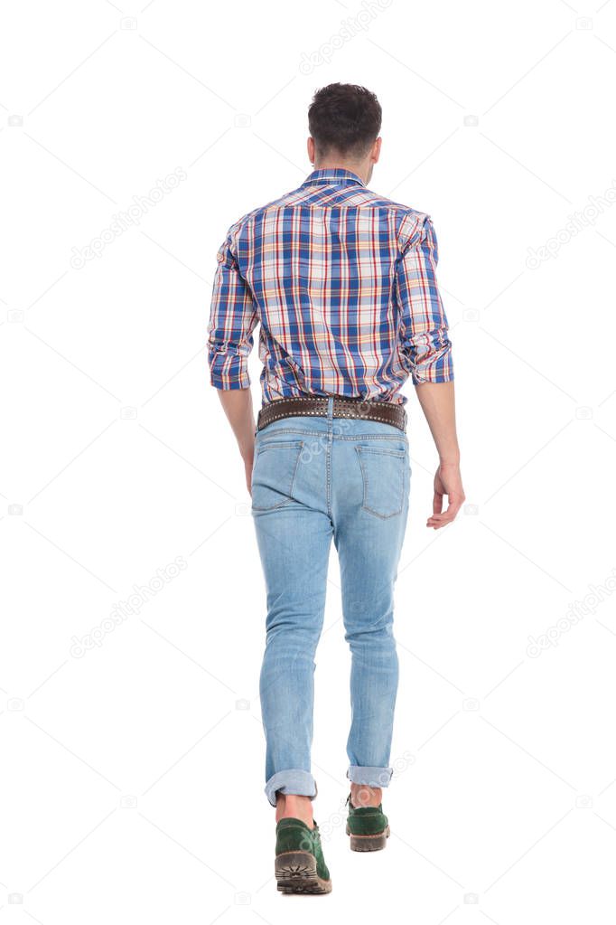rear view of young casual man wearing a shirt with checkers walking