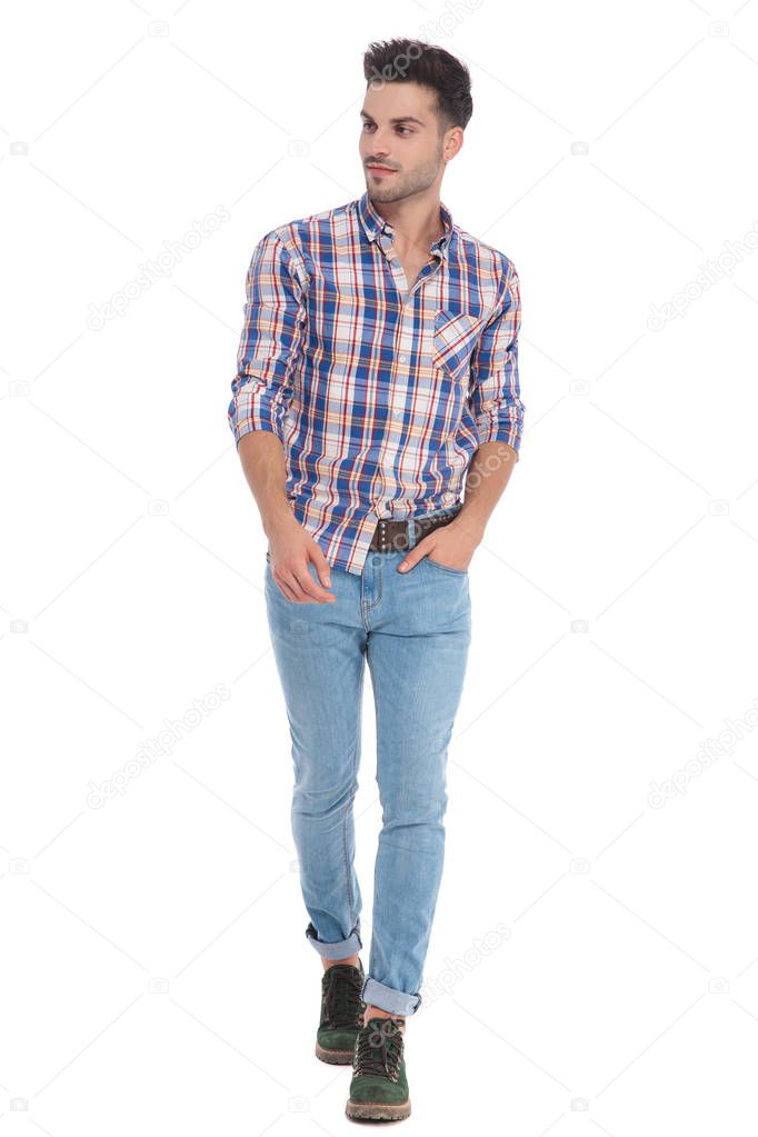 relaxed casual man wearing shirt with red checkers walking on white background and looking to side, full length picture