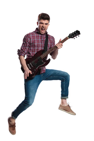 Jovem Guitarrista Pulando Para Lado Gritando Enquanto Tocava Sua Guitarra — Fotografia de Stock
