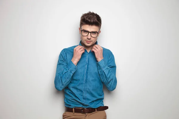青いシャツと明るい背景の中に立って襟を固定のサングラスを身に着けているセクシーな学生の肖像画 — ストック写真