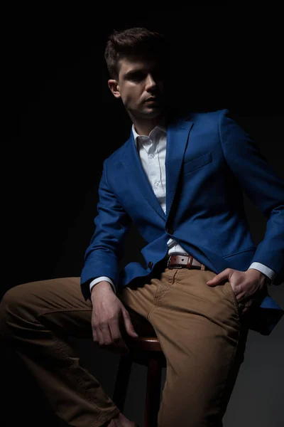 Misterioso Homem Sentado Vestindo Terno Azul Segurando Bolsos Olha Para — Fotografia de Stock