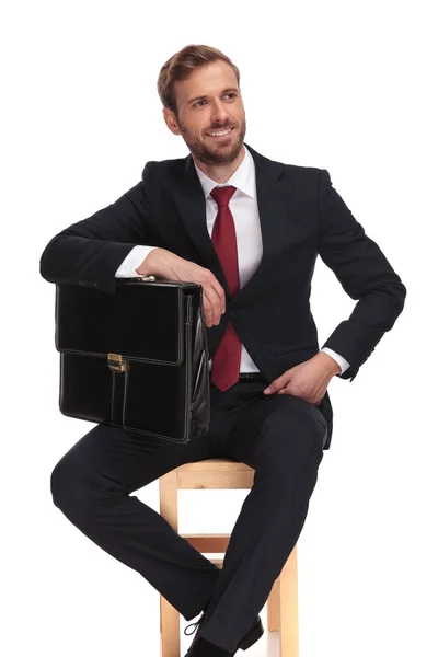 Biznesmen Trzymając Jego Walizki Pod Łokciem Wygląda Stronie Siedząc Krześle — Zdjęcie stockowe