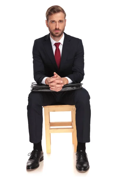 担心的生意人坐在木椅子上 在肘部在白色背景下的手提箱 全身图片 — 图库照片