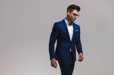 gri arka plan üzerinde yürüme smart casual adam yan görünüm