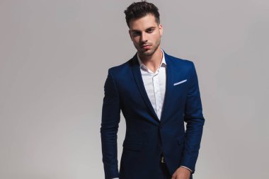 gri arka plan üzerinde duran genç yakışıklı bir zarif adam portresi