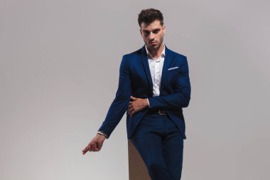 parmaklarını woden kutusunu gri arka plan üzerinde otururken yapışma dramatik moda adam