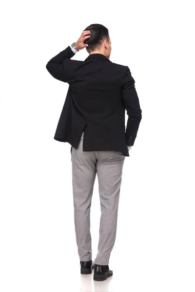 物思いにふけるビジネスマンの頭を押しながら側にしてポケットに手と白い背景の上に立っての背面図 — ストック写真