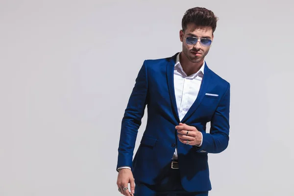 Drammatico Giovane Uomo Moda Abito Occhiali Sole Posa Sfondo Grigio — Foto Stock