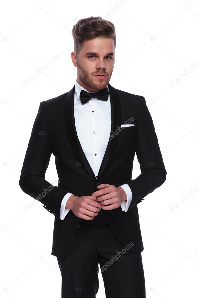 young groom holding palms together on white background