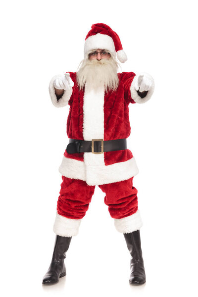 merry santa claus pointing fingers while standing with parted feet on white background