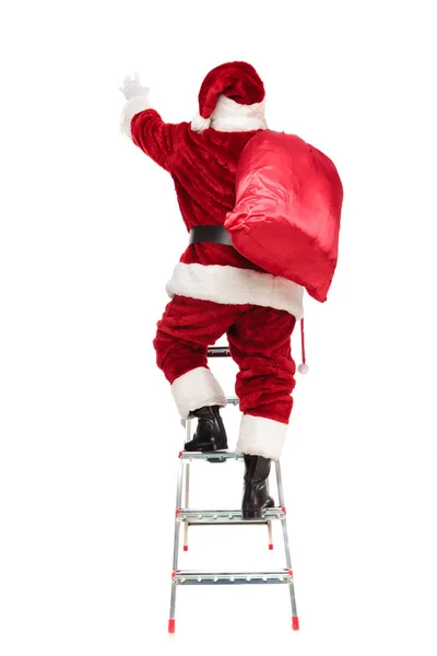 Zadní Pohled Santa Natahuje Ruku Při Lezení Žebříku Stojící Bílém — Stock fotografie