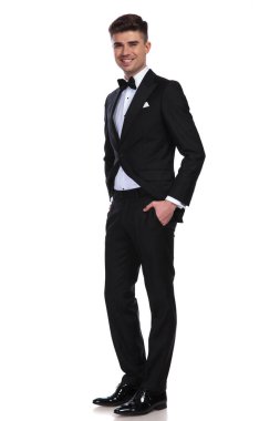 neşeli rahat damat elleri ceplerinde beyaz arka plan üzerinde duran ve gülümseyen, tam vücut resim