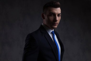 siyah duvar kağıdı arka plan üzerinde mavi kravat ayakta giymek çekici işadamı portresi