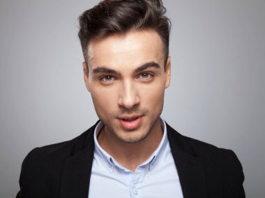 ışık gri arka plan üzerinde siyah takım elbise duran baştan çıkarıcı akıllı casual adam portresi