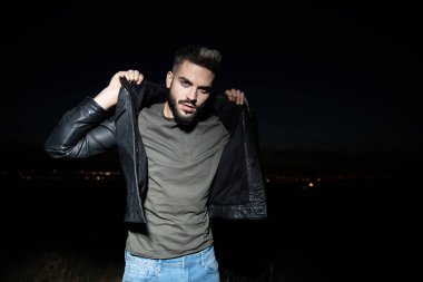 deri ceket yaka ayakta açık bir alanda gece tutan adam portresi