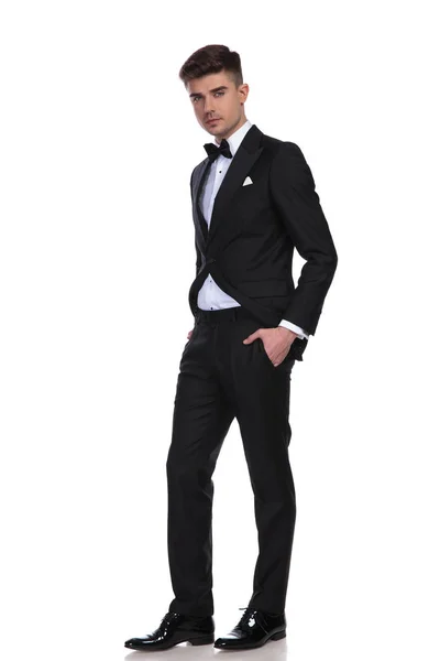 Elegancki Mężczyzna Stojący Czarny Smoking Ręce Kieszenie Białym Tle — Zdjęcie stockowe