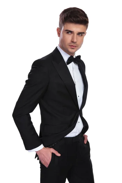 穿着黑色燕尾服的轻松优雅的男人的肖像 一边站在白色的背景 — 图库照片