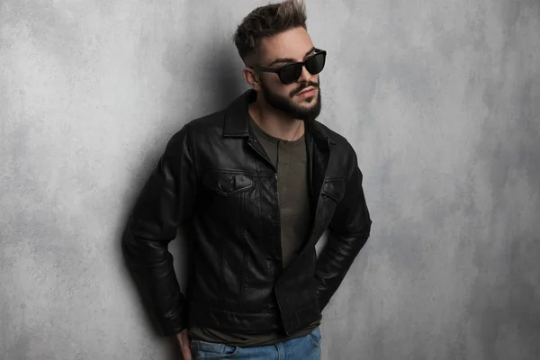 Portrait Curious Man Wearing Leather Jacket Sunglasses Leaning Grey Wallpaper — Stock Photo, Image