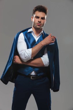 katlanmış silah ile açık gri renkli mavi takımı ayakta emin akıllı casual adam portresi