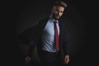 çekici işadamı duran çırpınan bir donanma takım siyah arka plan üzerinde elbise