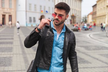 deri ceket giyiyor ve yan duran isteyen bir şehir molası genç adam portresi