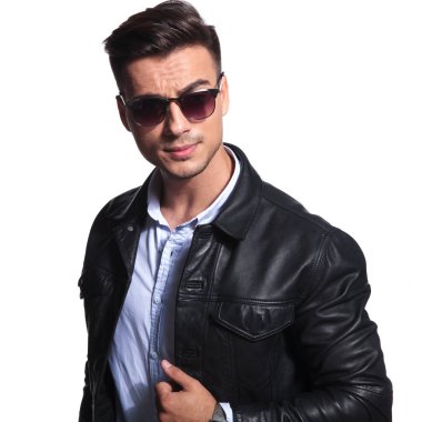 deri ceket yaka tutarak ve kırmızı güneş gözlüğü takıyor gülümseyen iş adamı beyaz zemin üzerine, portre resim standları