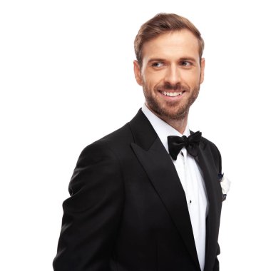 tarafına bakarak ve beyaz arka plan üzerinde dururken gülümseyen yakışıklı işadamı portresi