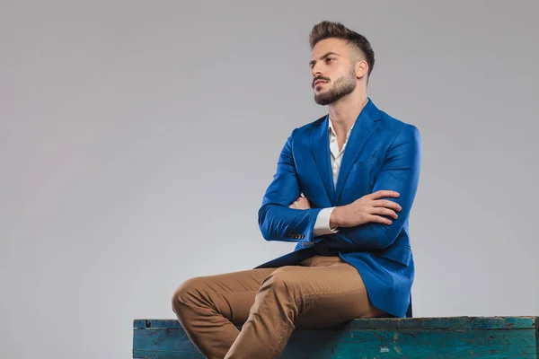 Retrato Sentado Confiante Casual Homem Olhando Para Lado Fundo Cinza — Fotografia de Stock